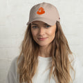 Woman wearing a beige cap with a logo on a white background