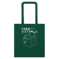 A dark green canvas tote bag with two handles, featuring a white line art graphic of a cucumber sitting on a block with the text 'COOL as a CUCUMBER' printed on the front, set against a plain white background.