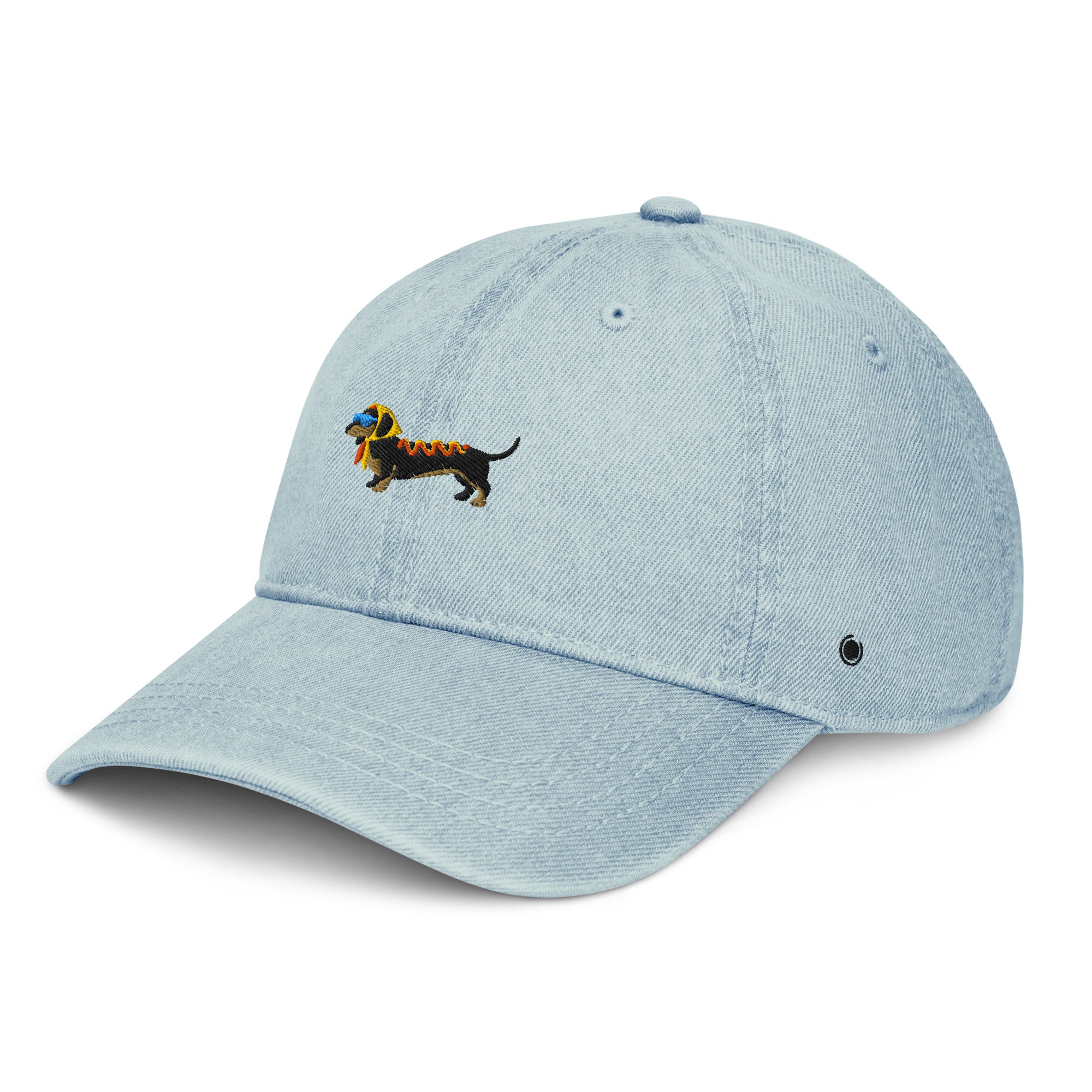 A light blue denim baseball cap featuring an embroidered dachshund dog on the front. The dog is black with a yellow headscarf, a pair of light blue sunglasses, and ketchup and mustard on its back.