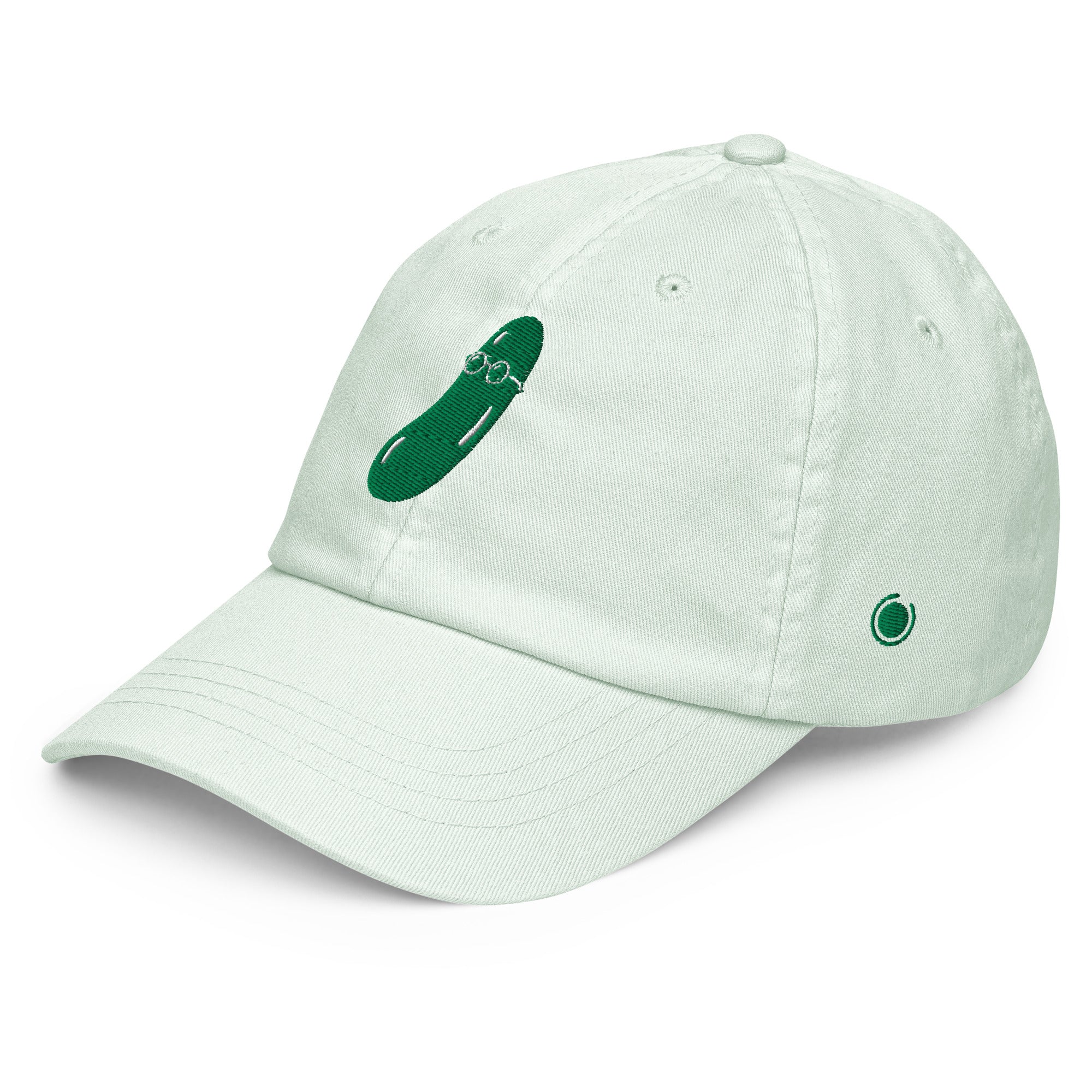 A light mint green dad hat baseball cap featuring a green embroidered cucumber graphic with glasses on the front panel and a small matching green circular logo on the side, set against a plain white background.