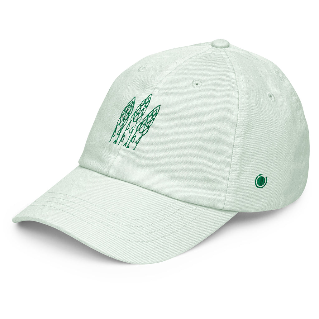 A light mint green dad hat baseball cap featuring a green embroidered graphic of three asparagus spears on the front and a small green circular logo on the side, set against a plain white background.
