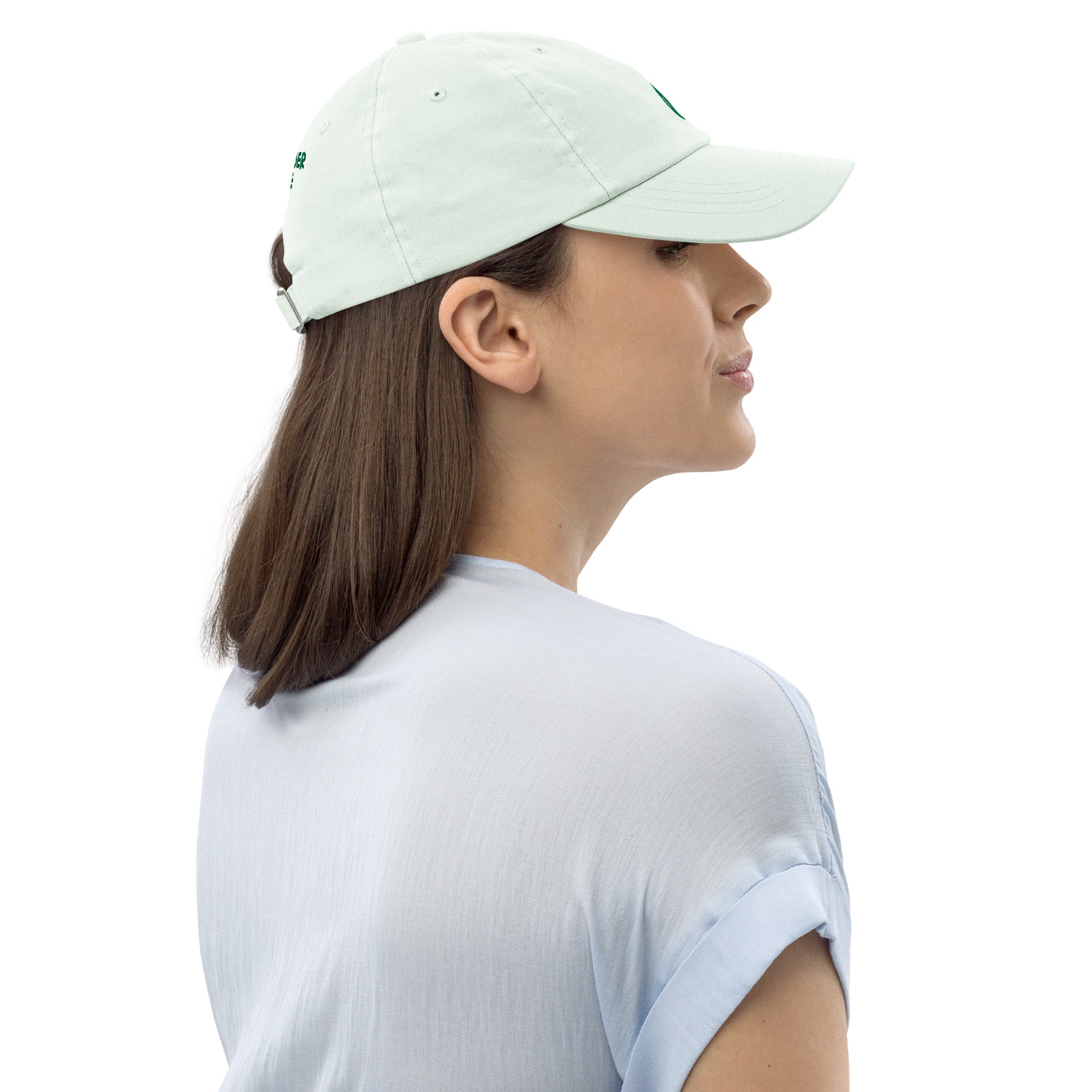 Woman wearing a light green baseball cap on a white background