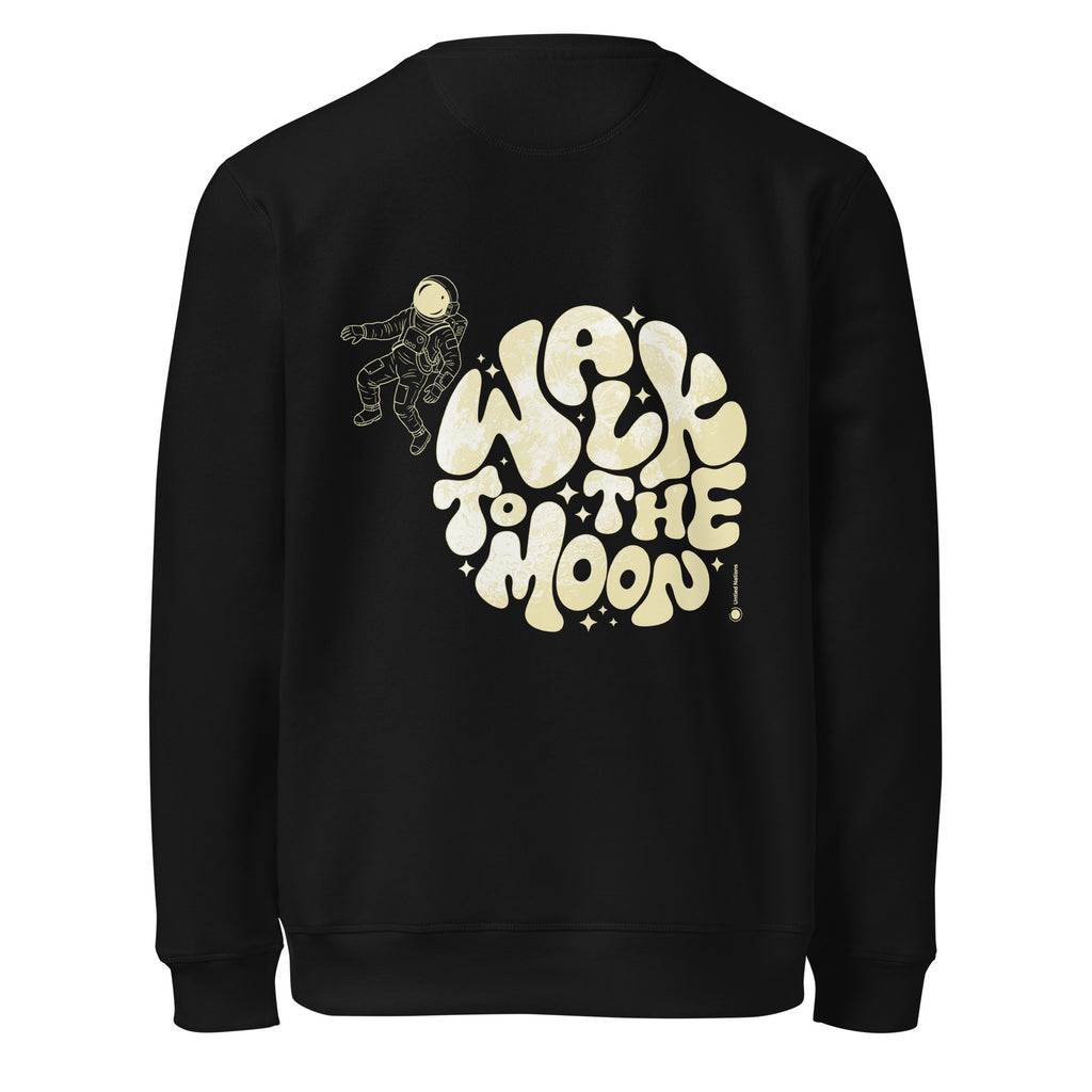 A black crewneck sweatshirt featuring a retro-style graphic on the front with the text 'WALK TO THE MOON' in a wavy cream-colored font, accompanied by a small astronaut illustration and star details.