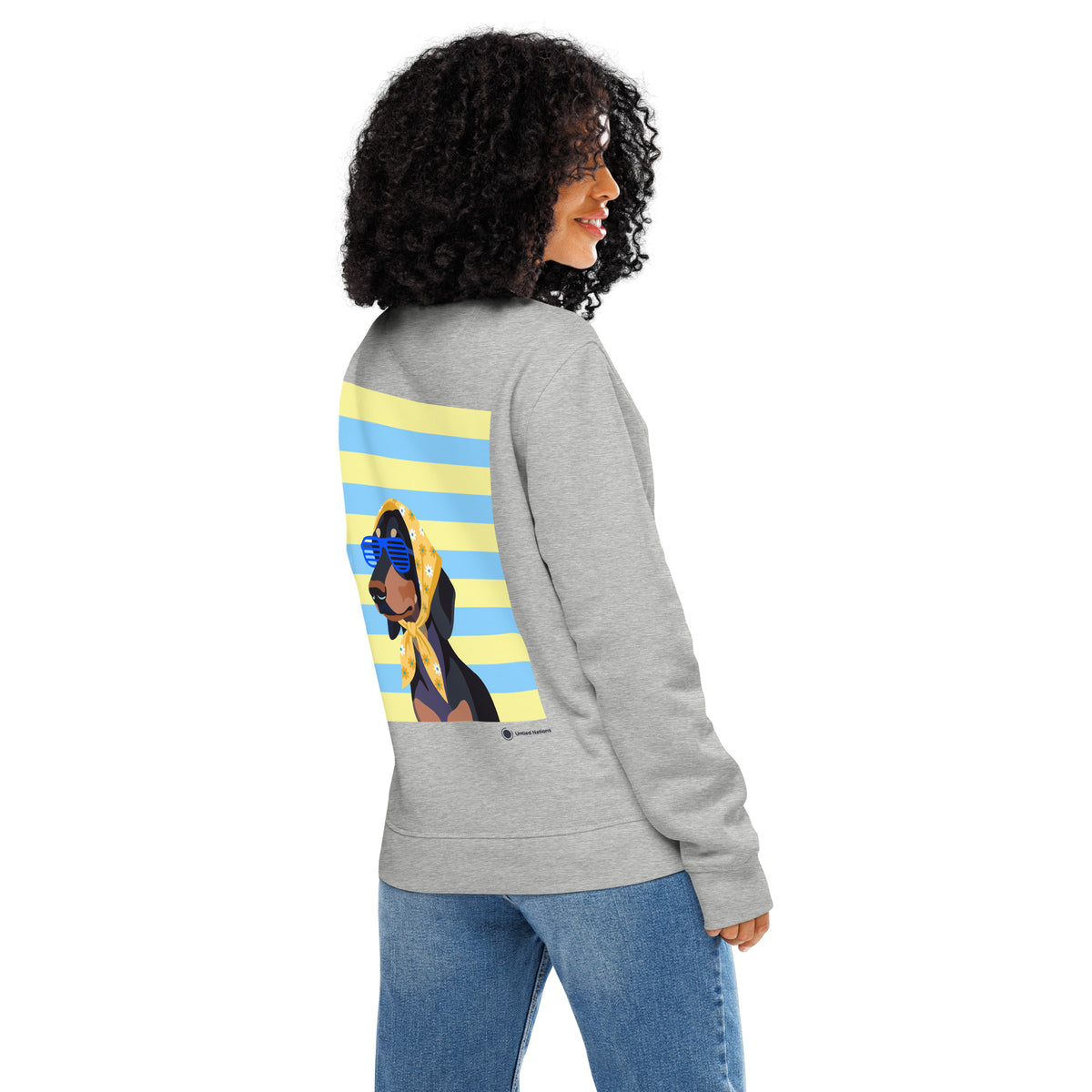A woman shown from the back wearing a heather gray sweatshirt with a large graphic print on the back, paired with blue jeans against a plain white background.