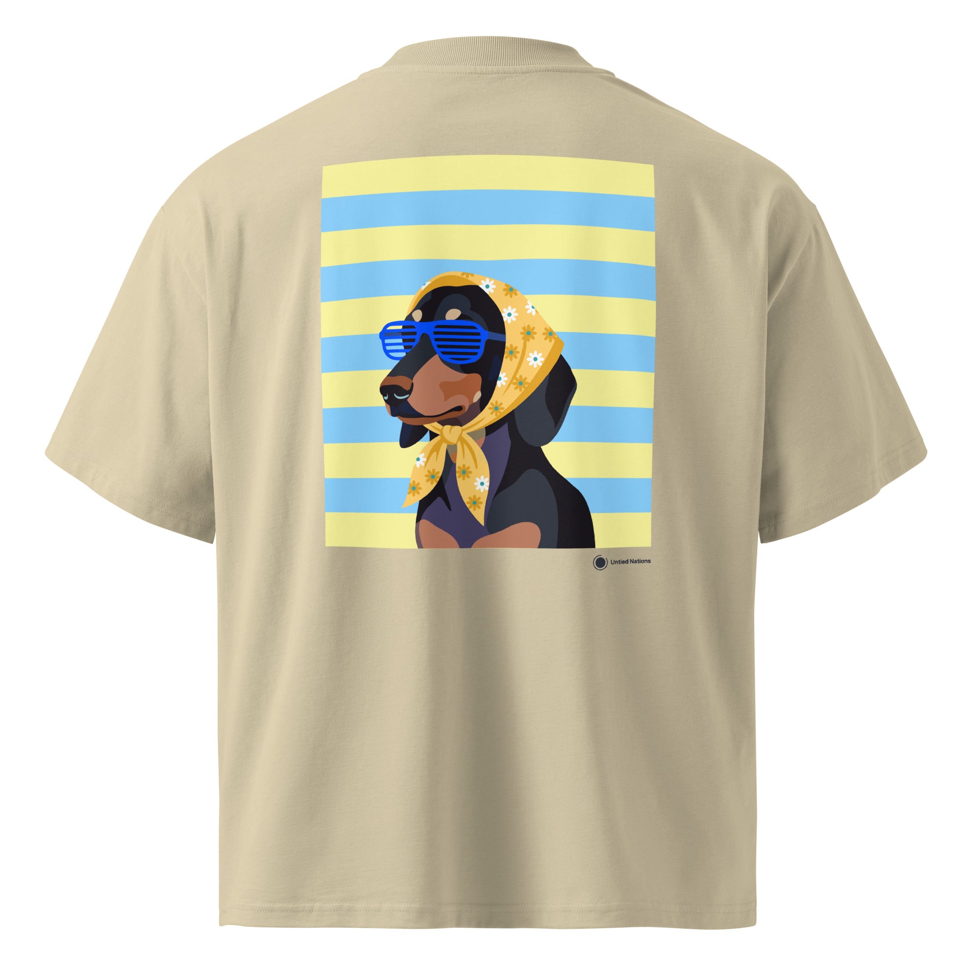 A beige short-sleeve t-shirt shown from the back, featuring a large graphic print of a dachshund wearing blue sunglasses and a yellow bandana against a yellow and blue striped background.