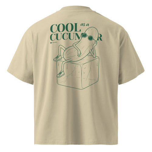 Beige short-sleeve t-shirt shown from the back, featuring a green graphic of a cucumber wearing sunglasses and sitting on an ice cube, with the text 'COOL as a CUCUMBER'.
