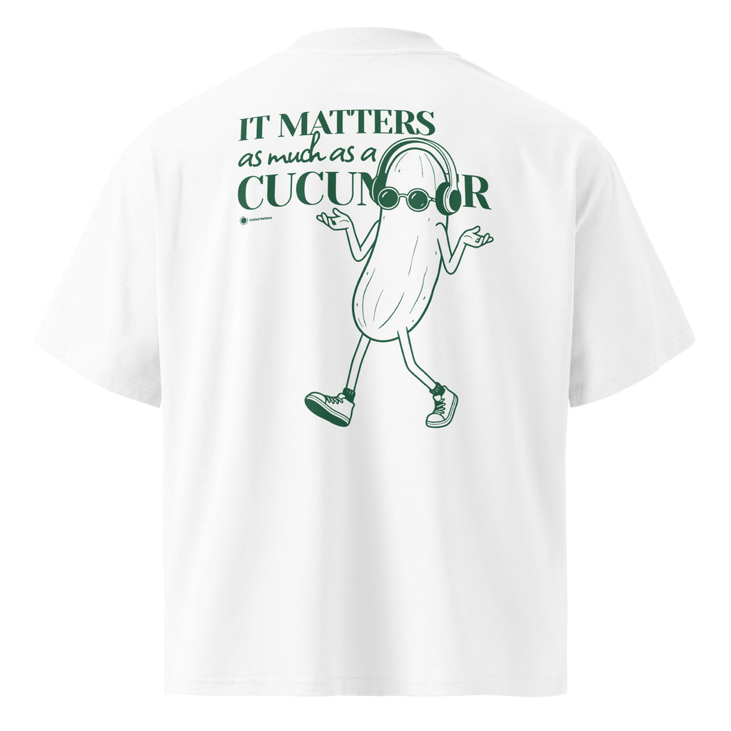White short-sleeve t-shirt shown from the back, featuring a green graphic of a walking cucumber character wearing glasses and headphones next to the text 'It matters as much as a cucumber'.