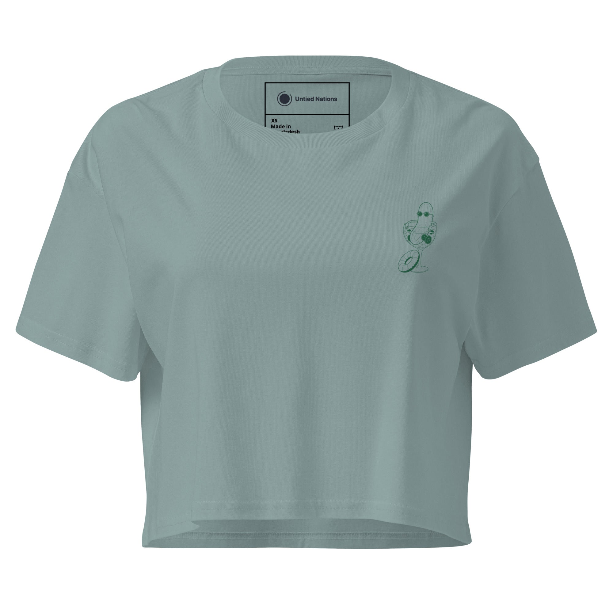 A teal crop top with an illustration of a cucumber wearing sunglasses sitting in a cocktail glass printed on the left chest.