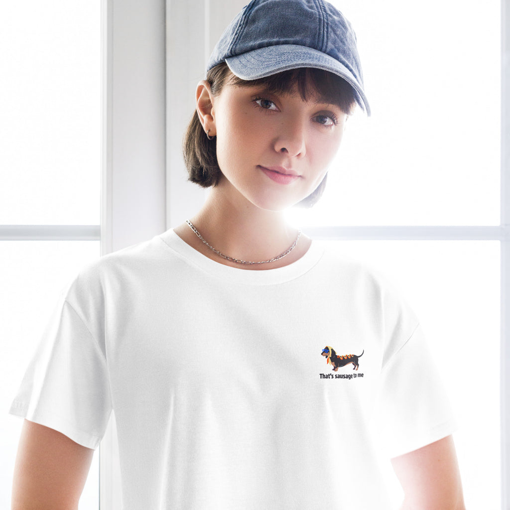 Person wearing a white t-shirt with text and a blue cap indoors.