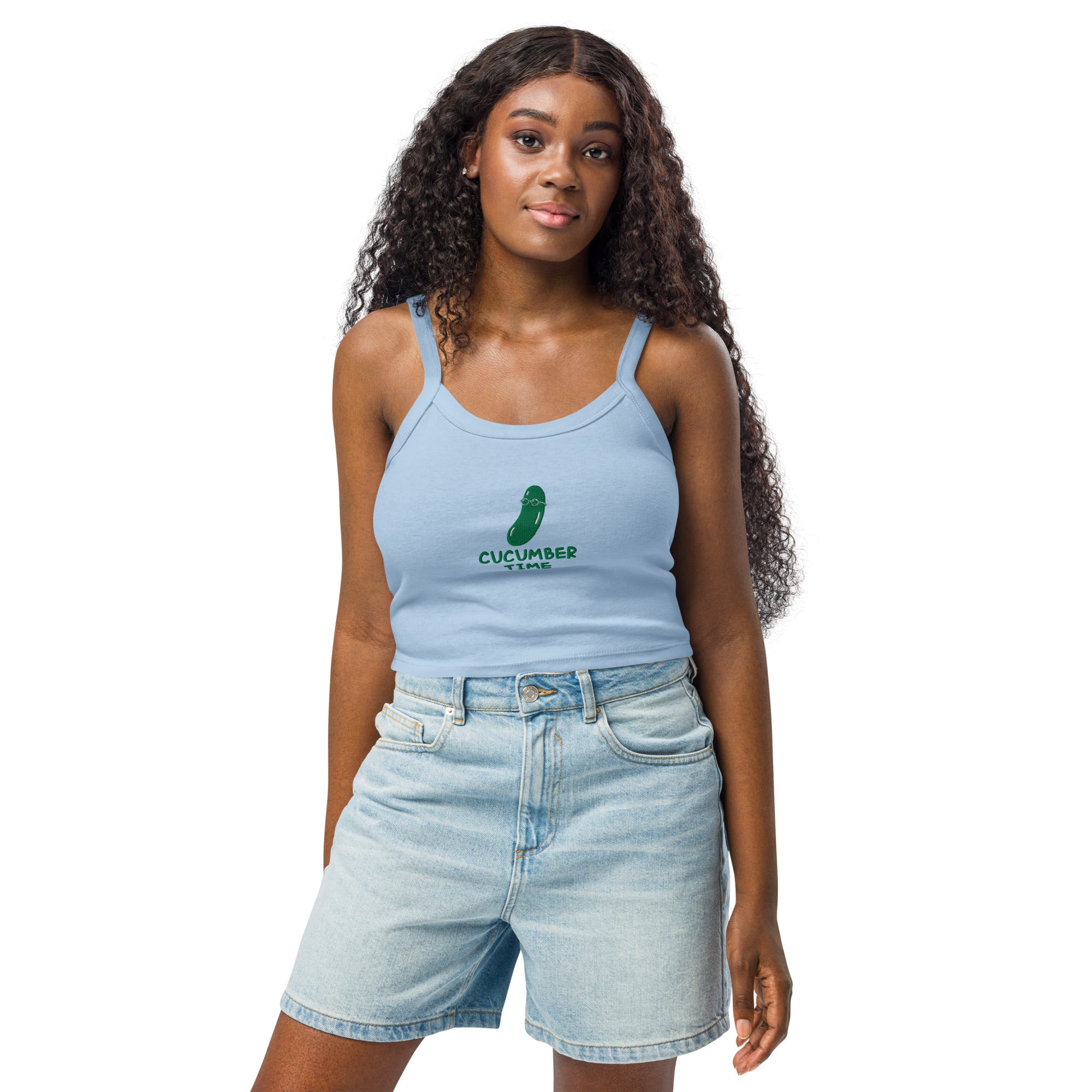 Woman wearing a light blue tank top and denim shorts on a white background
