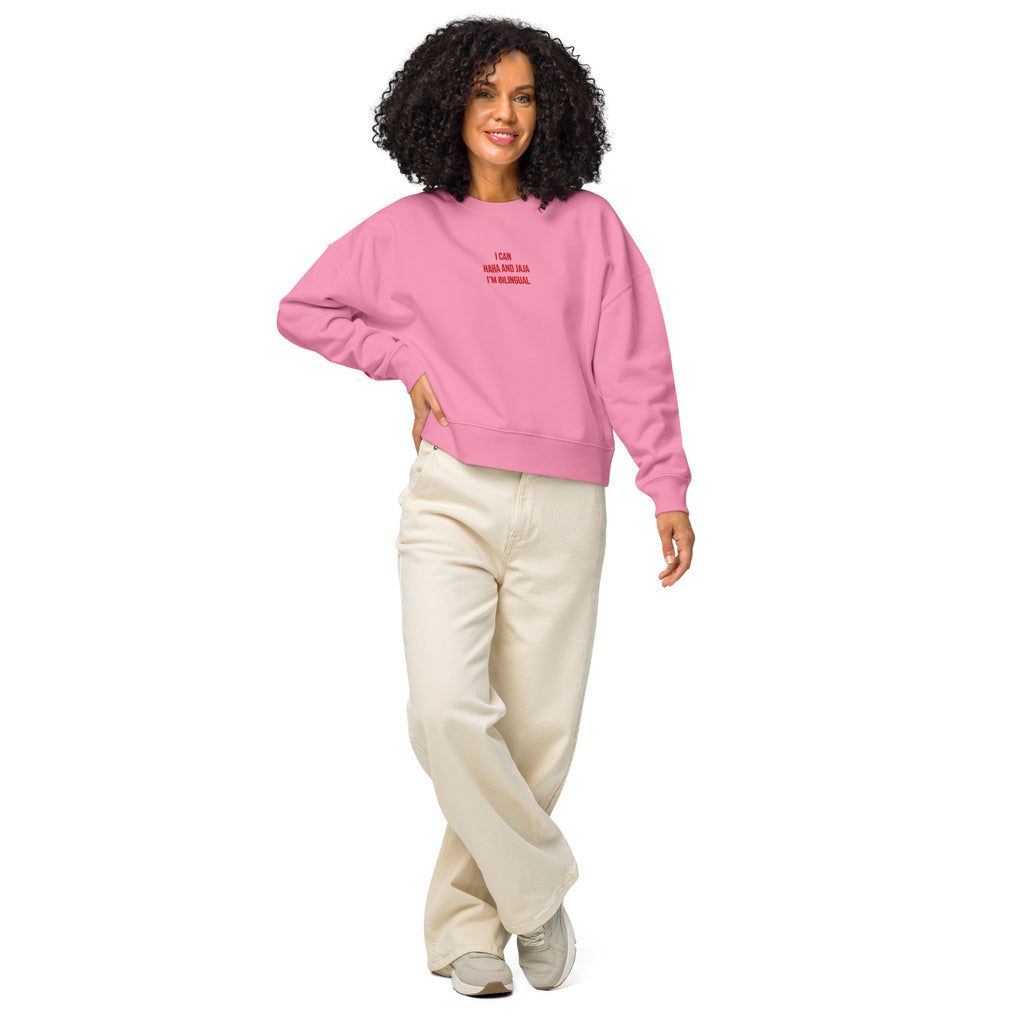 Woman wearing a pink sweatshirt with a logo on a white background